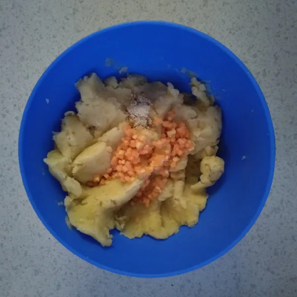 Masukkan potongan wortel ke dalam kentang yang sudah dihaluskan. Tambahkan 1/4 sdt penyedap rasa. Campur hingga rata.