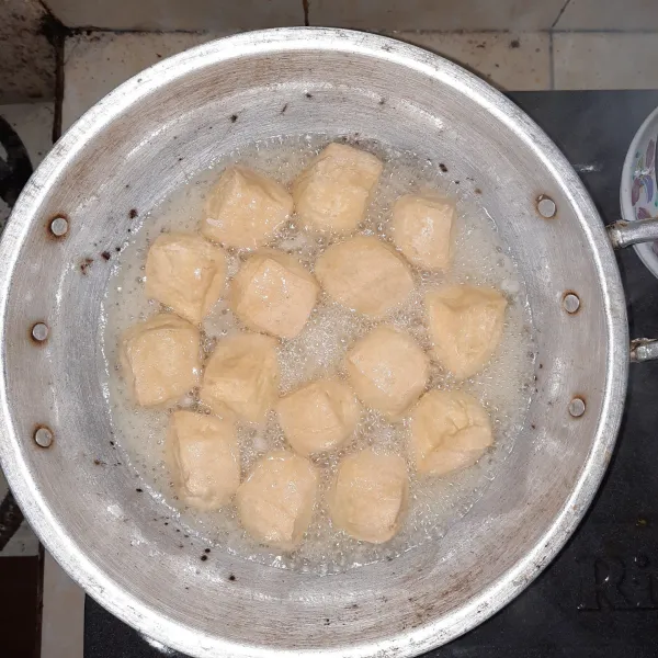 Masukkan 50 ml adonan tepung ke dalam tahu yang sedang di goreng, tunggu hingga buih²nya agak menghilang baru diaduk, agar tepungnya menempel di tahu.