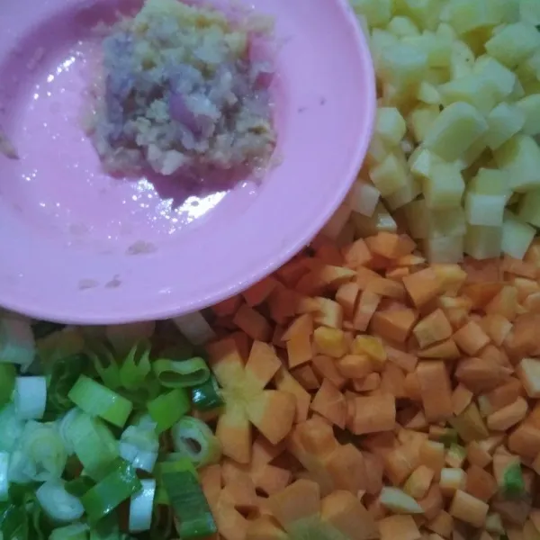 Siapkan isian, cincang bawang merah dan bawang putih. Potong dadu kentang dan wortel. Rajang daun bawang.