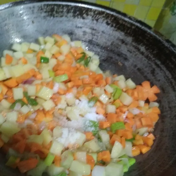 Masukkan kentang dan wortel. Tumis hingga layu/empuk, lalu tambahkan garam, gula, merica bubuk, dan kaldu jamur. Serta tambahkan juga rajangan daun bawang, koreksi rasa. Tumis hingga isian masak.