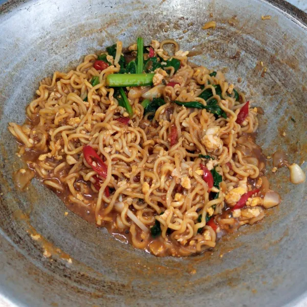 Masukkan bumbu mie instan, kecap manis dan saos sambal. Aduk rata. Icip rasa. Sajikan.
