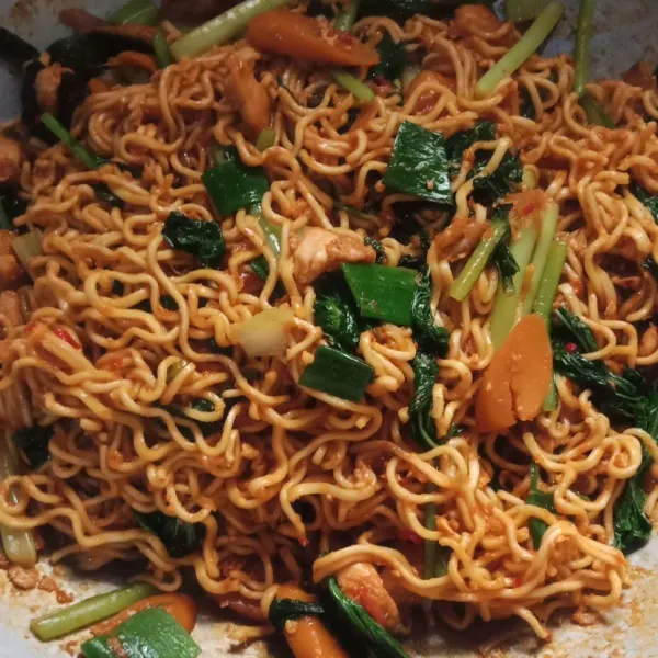 Aduk rata mie hingga tercampur dengan bumbu, beri irisan daun bawang, tes rasa.