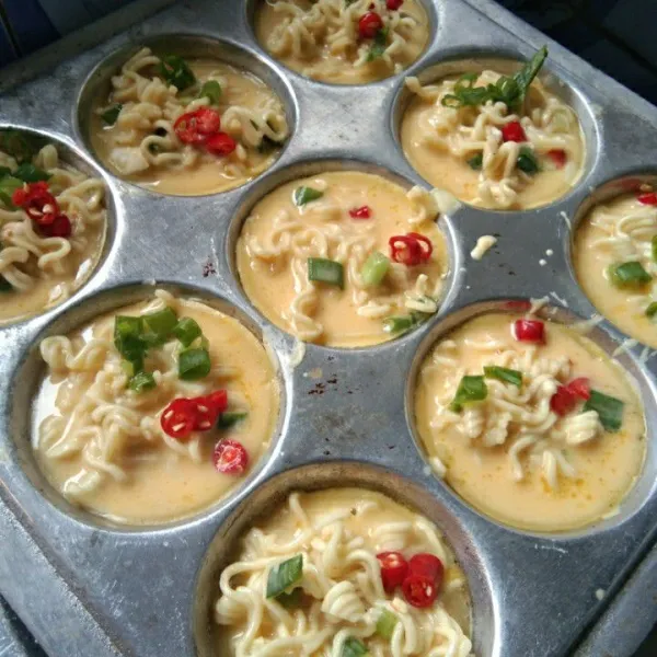 Beri irisan bawang daun dan irisan cabe merah keriting, tutup kembali masak hingga matang.