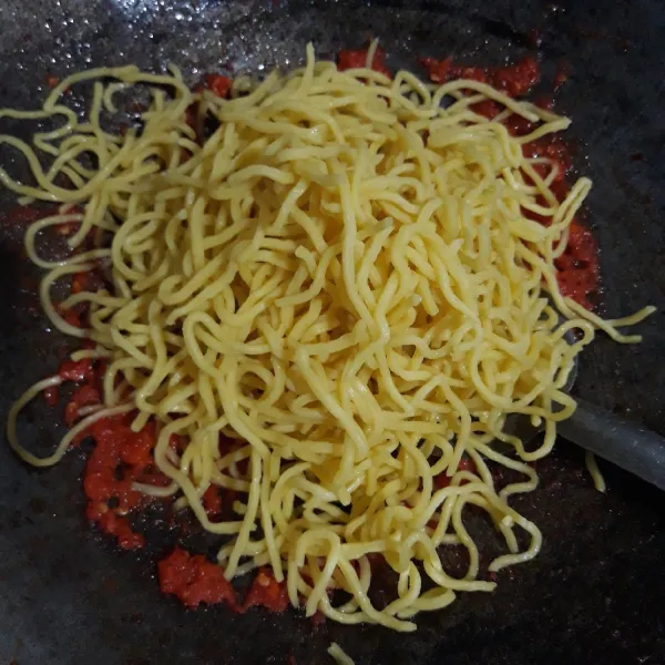 Masukkan mie kuning, aduk-aduk sampai tercampur rata.