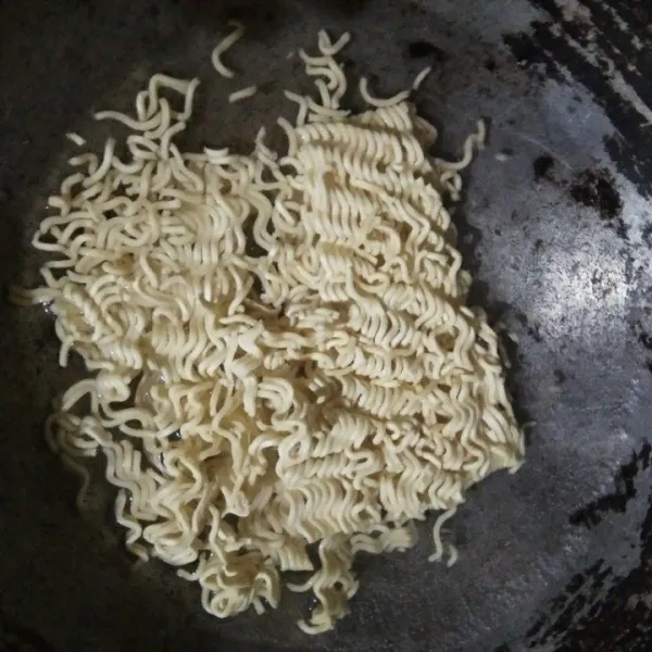 Rebus mie hingga setengah matang, angkat dan tiriskan.