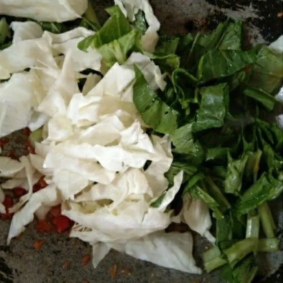 Masukan irisan kol dan daun sawi hijau, aduk rata.