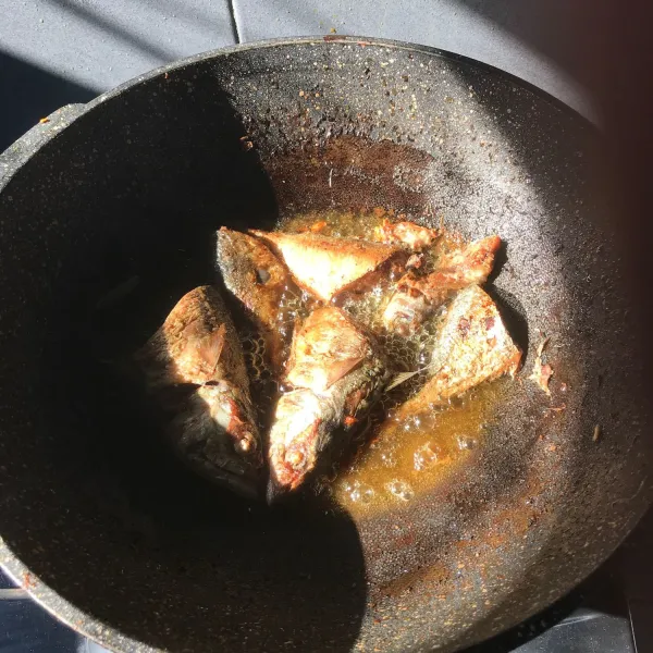 Lalu goreng ikan sampai kering, angkat dan sisihkan, ulangi sampai semua ikan tergoreng.