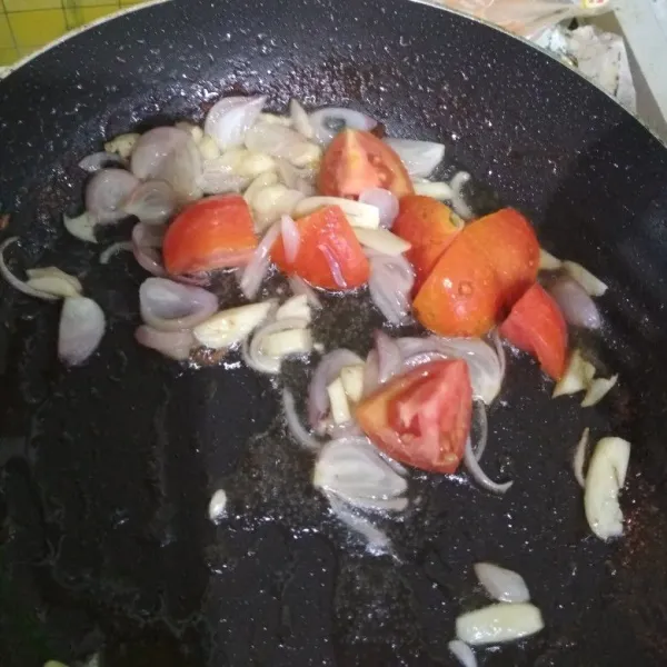 Tumis bawang merah dan bawang hijau hingga harum, lalu masukkan tomat, tumis hingga tomat layu.