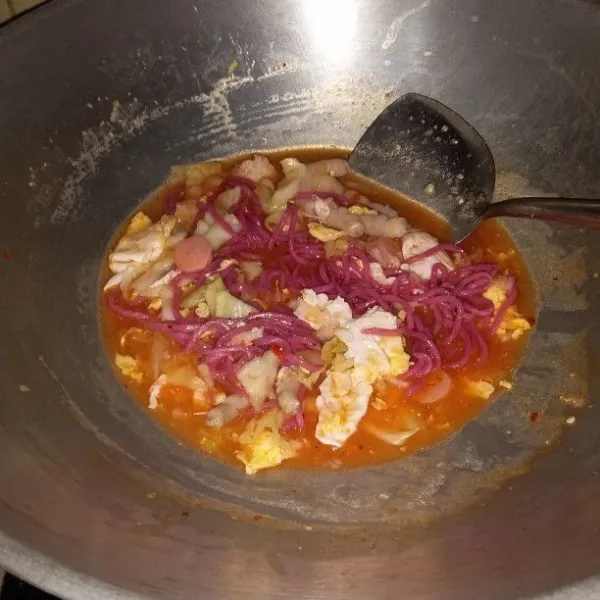 Tambahkan saus sambal dan mie merah. Aduk hingga mie tidak menggumpal. Rebus hingga mie matang. Matikan api.