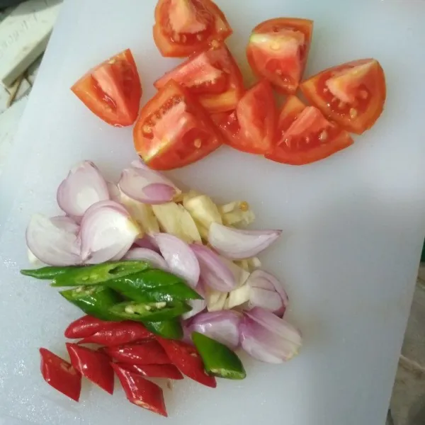 Belah tomat menjadi beberapa bagian, iris tipis bawang merah dan bawang putih, iris menyerong cabe merah dan cabe hijau. Sisihkan.