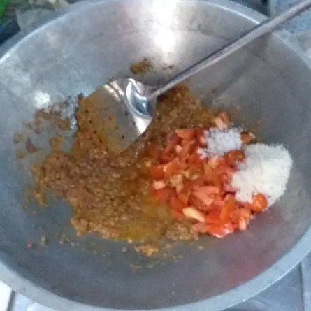 Masukkan tomat dan ranggam (buah rampai), serta bumbu garam, gula, dan penyedap rasa kaldu jamur. Aduk dan cek rasa