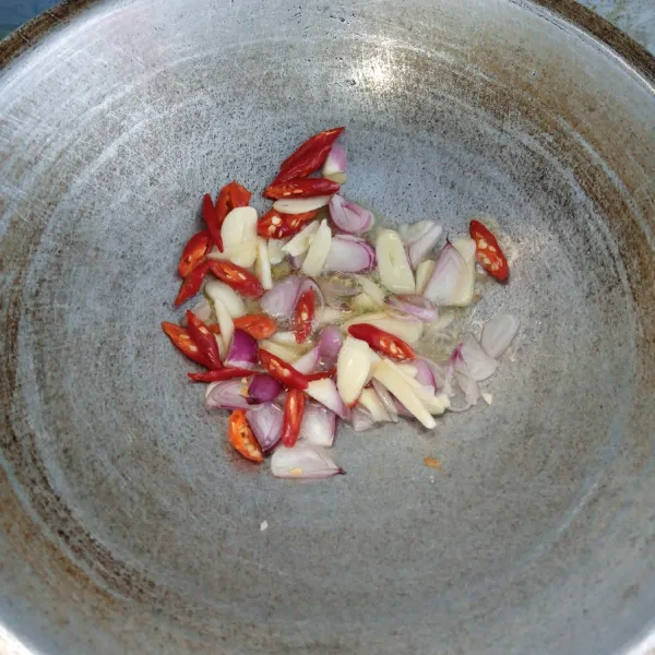 Tumis bawang merah, bawang putih, cabai keriting dan cabai rawit sampai harum dan layu.