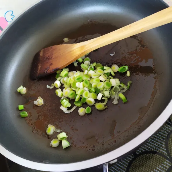Tumis potongan daun bawang hingga harum.