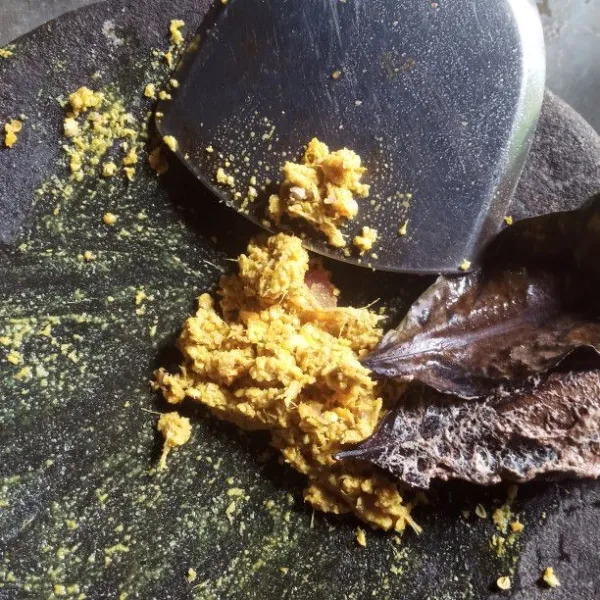 Siapkan cobek. Masukan bawang putih, bawang merah, ketumbar, kemiri, jahe dan kunyit. Uleg sampai halus.