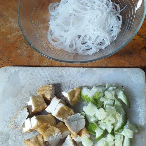 Celor bihun dan potong-potong tahu goreng dan timun.