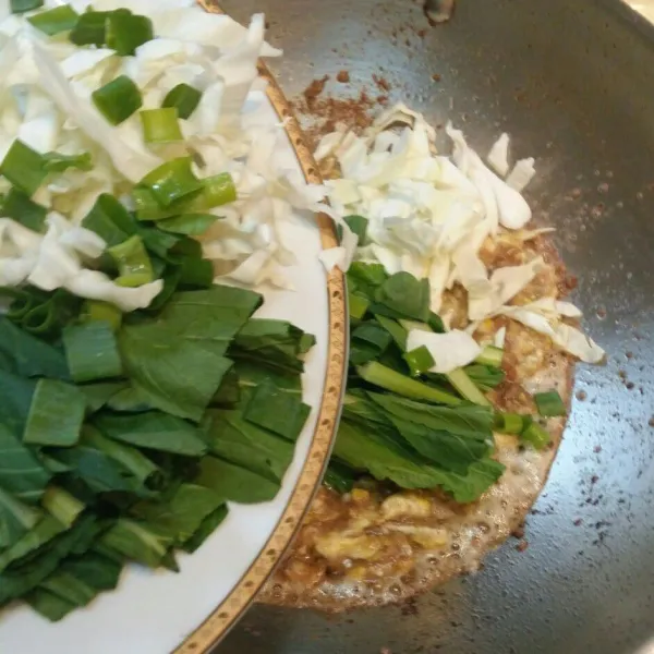Masukan sayuran, daun bawang dan ebi, aduk rata.