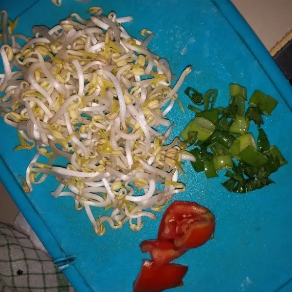 Siangi taoge. Cuci semua sayuran, tiriskan. Rajang bawang daun, daun seledri. Potong dadu tomat.