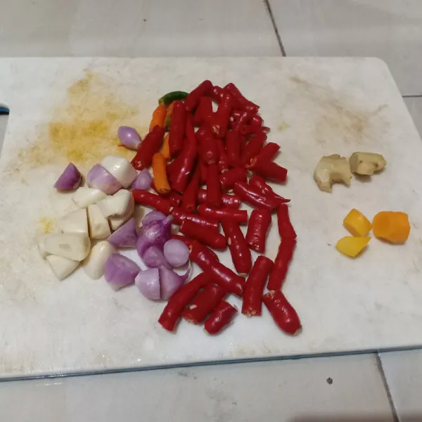 Siapkan bumbu halus: potong cabai merah keriting, jahe, kunyit, bawang merah, dan bawang putih