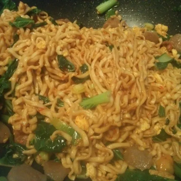 Masukan mie yg sudah di campur kecap tadi, aduk rata lalu tes rasanya, aduk terus hingga sawi matang, jika semua sudah mie tek tek goreng siap di hidangkan selagi hangat.