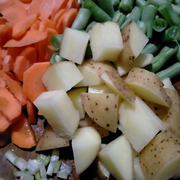 Potong-potong kentang, buncis, wortel dan daun bawang.