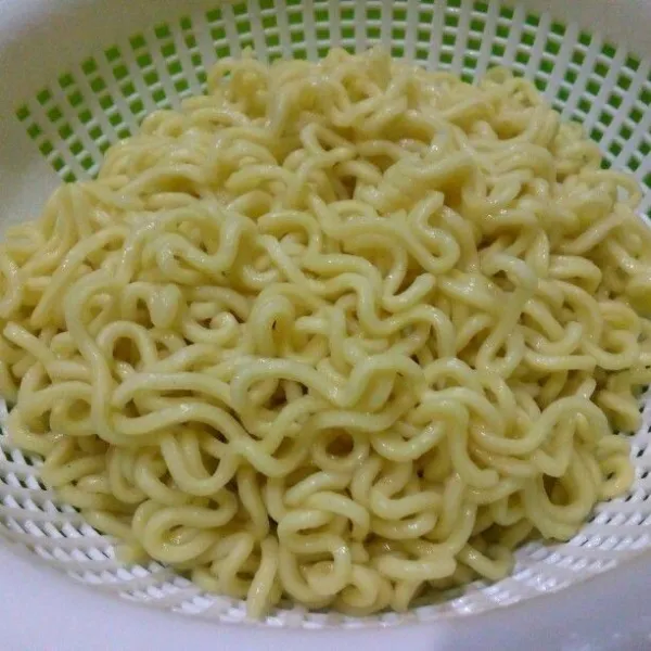 Rebus mie telur sampai setengah lunak, tiriskan. Beri sedikit minyak goreng, campur rata agar mie tidak menggumpal.