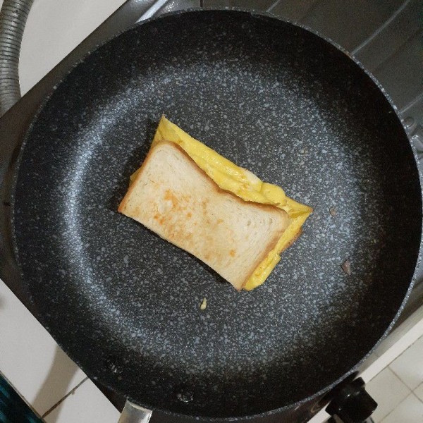 Lalu lipat rotinya agar membentuk seperti sandwich. Panggang kedua sisi hingga kering dan sedikit kecoklatan. Sajikan.