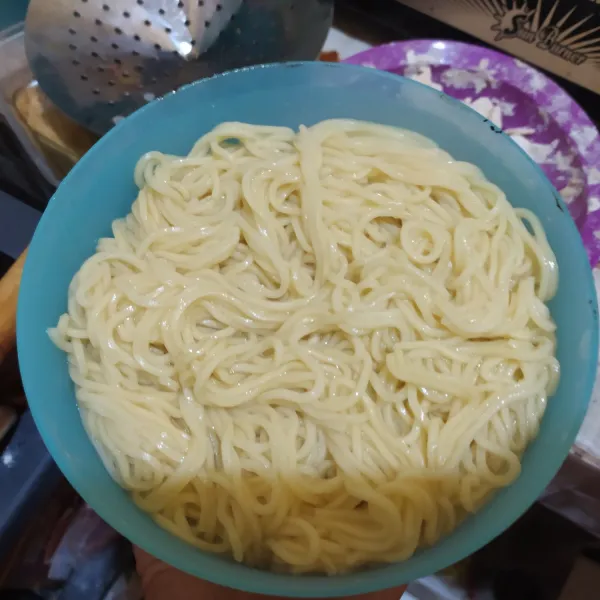 Rebus mie, tambahkan sedikit minyak dan garam pada air rebusannya, sisihkan.