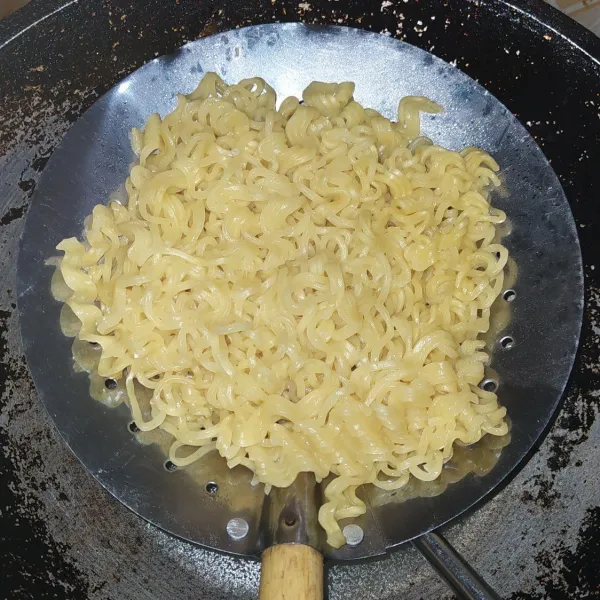Rebus mie lalu tiriskan, jangan sampai terlalu lembek.