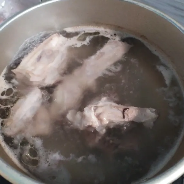 Membuat kuah kaldu, sisihkan air, masukkan tulangan ayam dan bawang putih, rebus hingga keluar kaldunya.