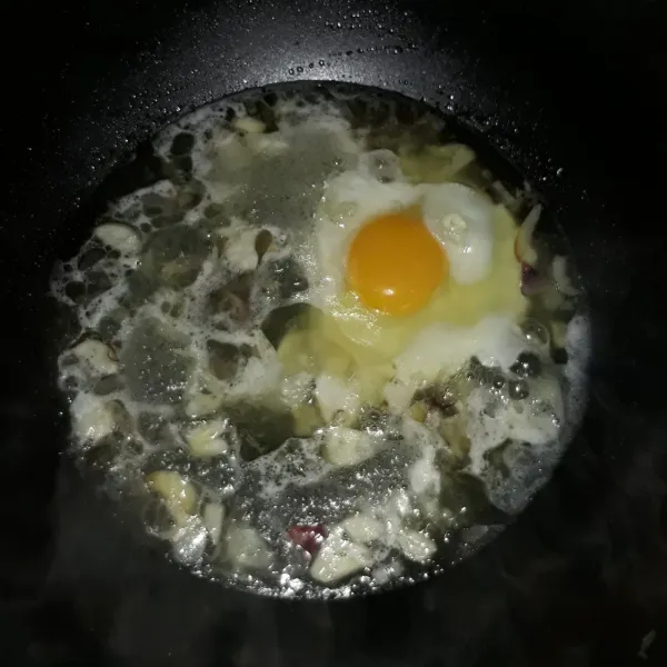 Tambahkan air, masak sampai mendidih lalu masukkan telur. Masak hingga telur setengah matang.