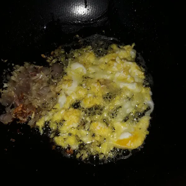 Sisihkan bawang putih dan bawang merah dipinggiran wajan, lalu masukkan telur dan buat orak-arik telur.