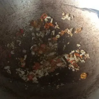 Tumis bawang putih dan cabai rawit dengan secukupnya minyak goreng hingga harum dan sedikit kecoklatan.