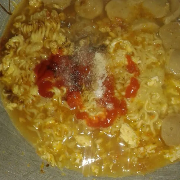 Tambahkan garam, gula, lada bubuk, kecap, saus sambal dan saus tomat. Aduk rata dan koreksi rasa sampai pas. Masak sampai mie dan kerupuk matang serta kuah sudah mulai mengental.