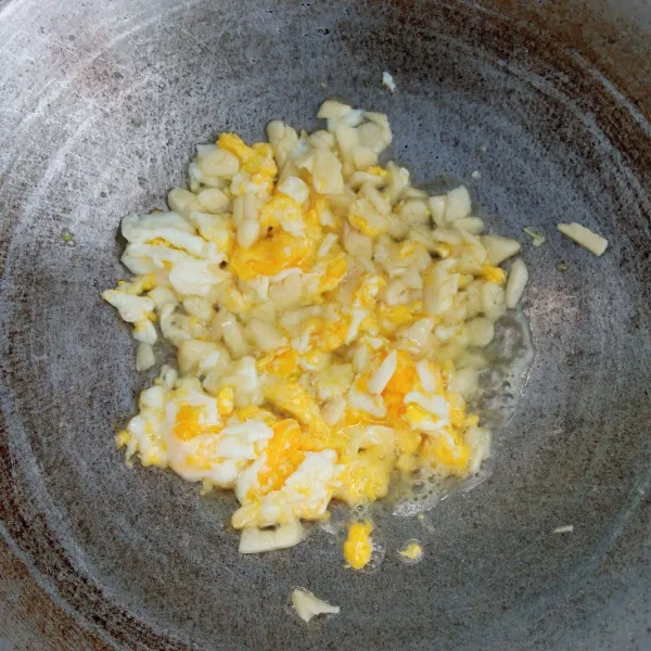 Ceplok telur. Orak-arik. Kemudian masukkan bawang putih. Masak sampai harum dan layu.