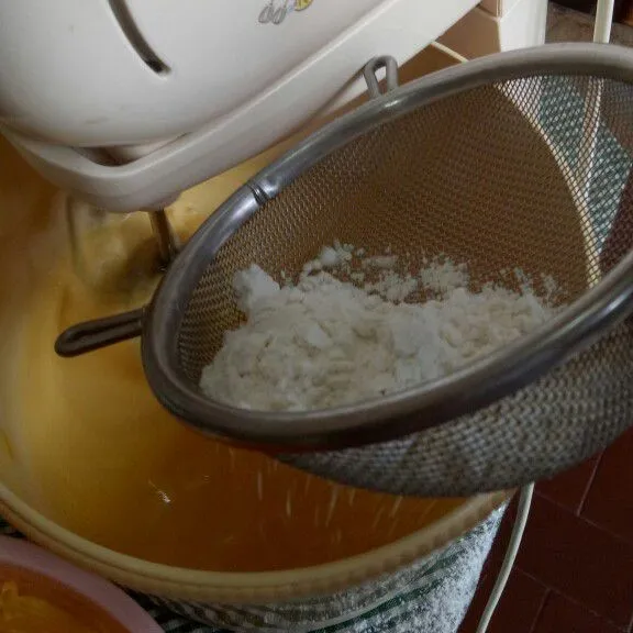 Tambahkan sebagian juga campuran tepung terigu dan baking powder. Lakukan secara bergantian hingga mentega dan tepung habis.
