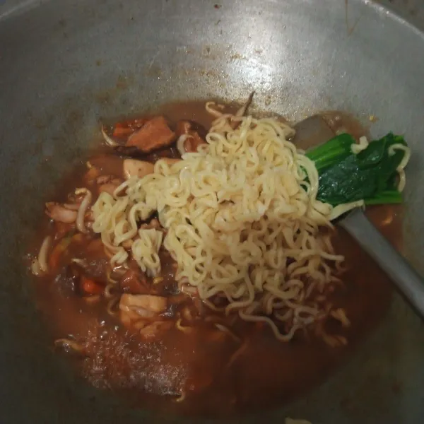Kemudian masukkan mie dan sawi, aduk rata.