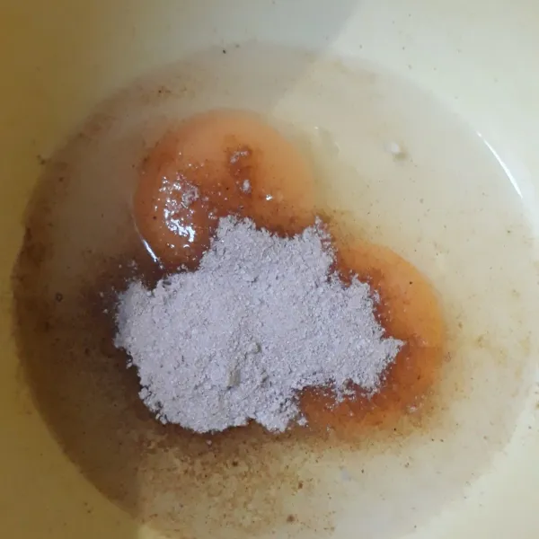 Dalam baskom pecahkan telur bebek dan bumbu instant dari kie goreng kocok rata.