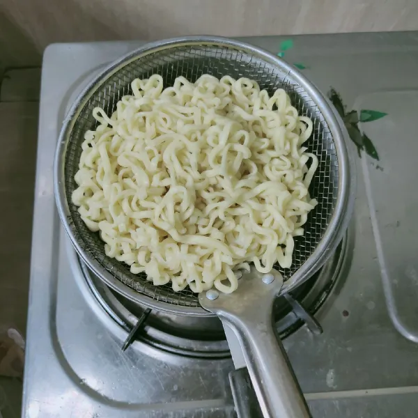 Pertama, mie urai pipih direbus hingga matang, kemudian angkat, tiriskan.