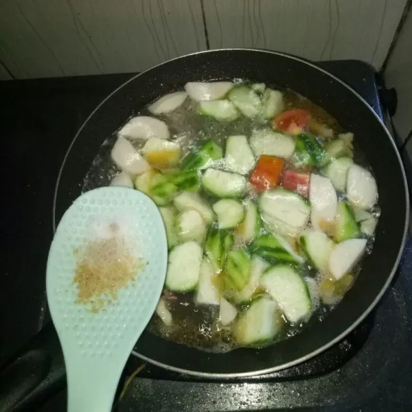 Setelah air mendidih, masukkan gambas, bakso ikan dan bumbu garam, gula, lada bubuk dan kaldu bubuk. Aduk rata, masak sampai gambas matang.