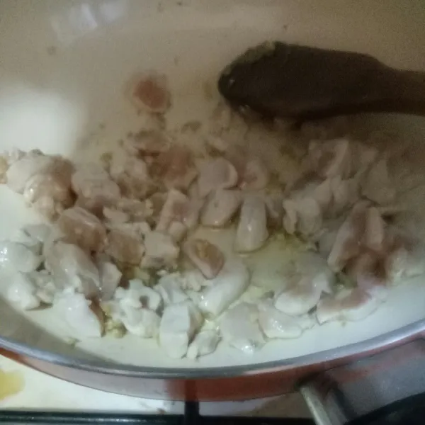 Tumis bawang putih dan jahe hingga harum, lalu masukkan daging ayam, masak hingga berubah warna.