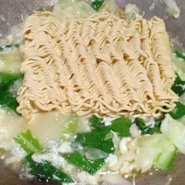 Beri air, biarkan hingga sayuran layu lalu masukkan mie.