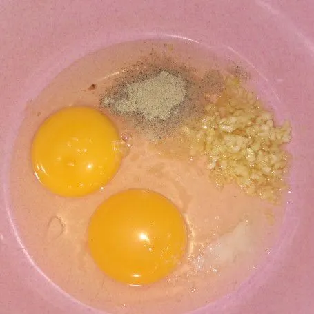Dalam wadah lain. Kocok telur, bawang putih cincang, penyedap jamur, merica dan garam.