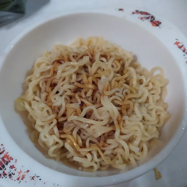 Rebus mie, lalu tambahkan kecap manis dan sedikit minyak sayur, aduk rata.