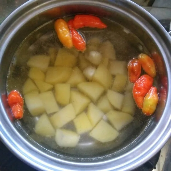 Rebus kentang, cabai rawit merah, & bawang putih. Tunggu hingga matang. Angkat dan tiriskan.