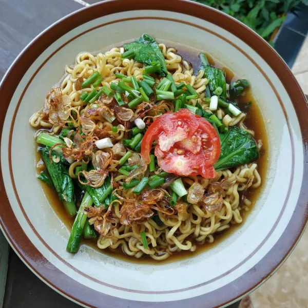 Penyajian, siapkan piring tata mie dan sawi. Tuang kuah kemudian taburi dengan bawang goreng, daun kucai dan irisan tomat.