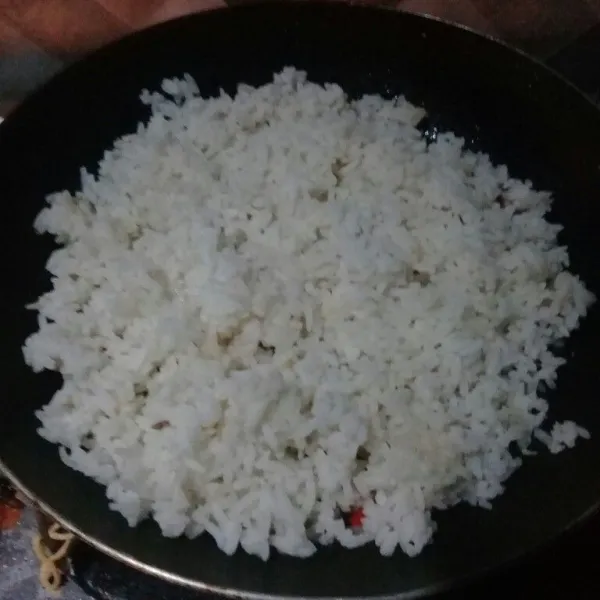 Tumis bawang putih dan cabe hingga layu, lalu masukan nasi. Aduk rata.