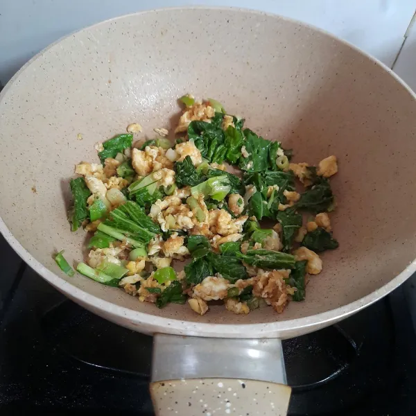 Masukkan potongan sawi dan irisan daun bawang. Aduk rata.
