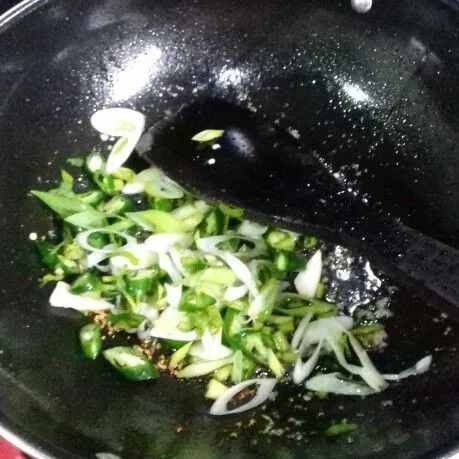 Masukkan daun bawang dan cabai hijau. Aduk rata.