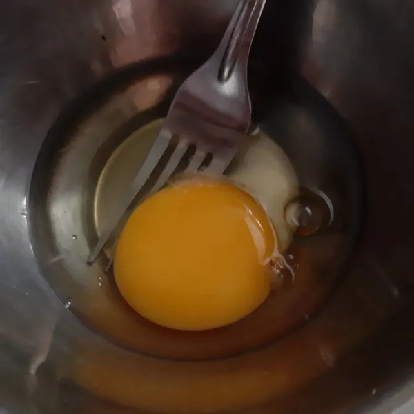 Kocok 1 butir telur dan sebagian kaldu jamur dengan garpu, asal rata. Sisihkan.