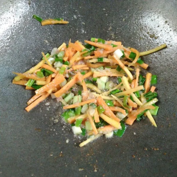 Masukkan daun bawang dan wortel, aduk. Masak sampai layu.